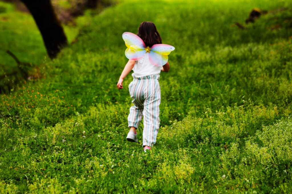 psicologia infantil terapia ninos araceli vazquez irun - Araceli Vázquez Psicóloga en Irún Niña con alas de mariposa corriendo por un campo verde, simbolizando la libertad y la expresión emocional a través de la psicología infantil en el Gabinete de Psicología Araceli Vázquez en Irún